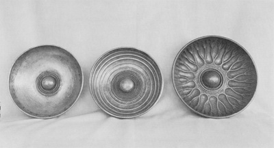 Three bronze bowls with convex bases, middle and right bowl decorated on the inside.