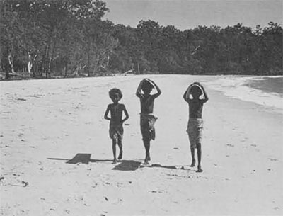 3 kids walking down beach