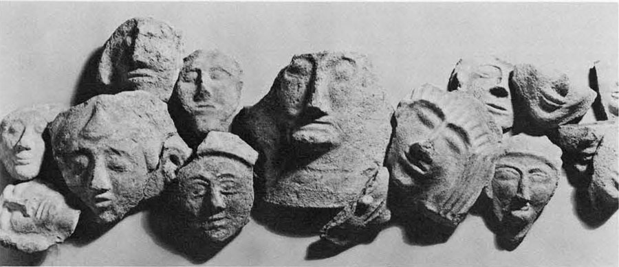 An assortment of pottery and stone fragments depicting human faces from Philistine sarcophagi.
