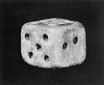 A cube die with notches in it, resembling a modern day die.