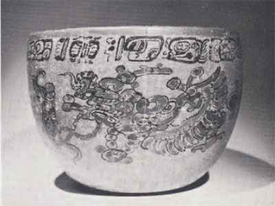 A bowl with a band of rectangular characters and a bird design.