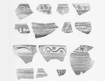 Several sherds of pottery with painted geometric designs and horizontal lines.