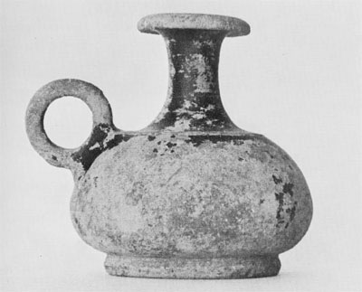 The ring-handled guttus, an oil jug, found in one of the 'cabin areas,' still preserves traces of its black glaze.
