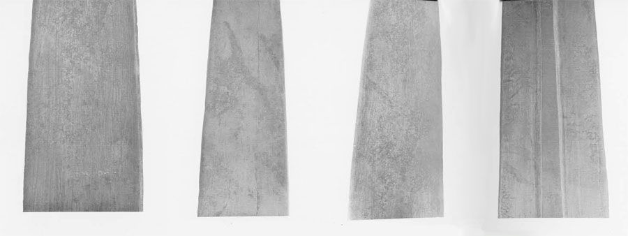 Close ups of the front and back of dagger blades, showing the striations in the metal.