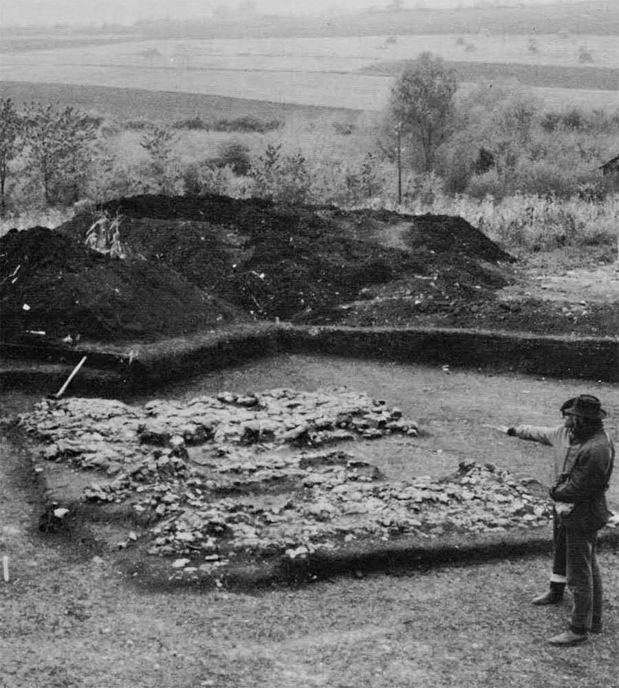 Divostin, showing excavated Vinča house floor in foreground, typical rural countryside in background. 