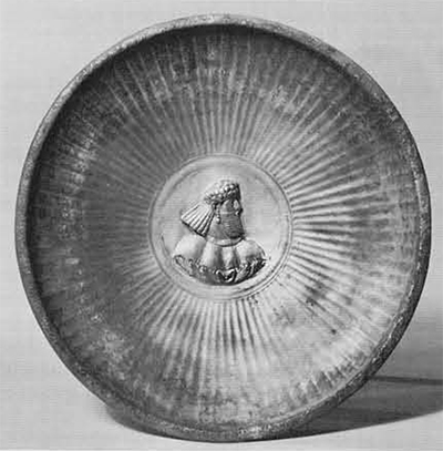 Silver bowl of the 3rd century A.D. Outside plain and without foot; inside, fluted side walls up to gilded center medallion with bearded male bust rising out of a leafy calyx. Diameter, 21 cm. Freer Gallery of Art Collection. 