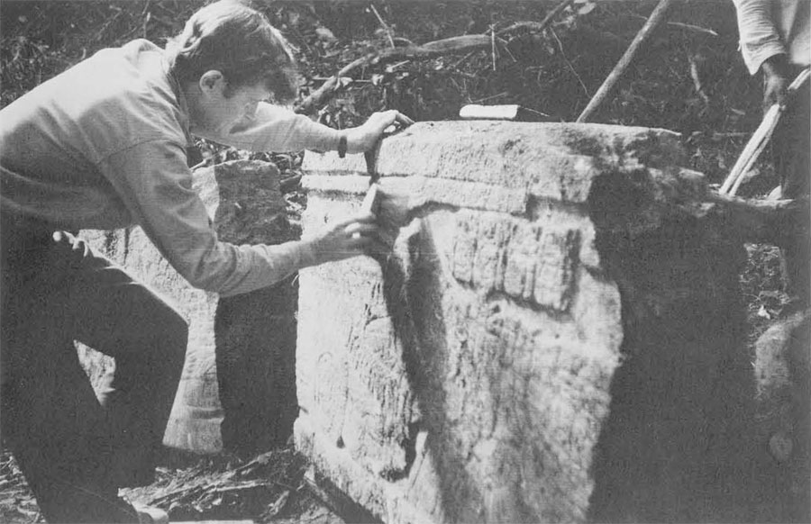 Ian Graham of Peabody cleaning front of stela in preparation for photographing it. He hopes to photograph and draw all remainign examples of Maya sculpture and writing before all are stolen or damaged by weather.