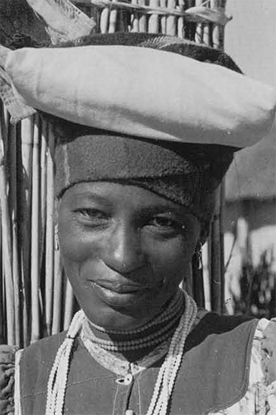 The head scarf is part of the traditional Herero dress. Its unusual shape is perhaps reminiscent of early headgear, made from leather, which had two horn-like protrusions. 