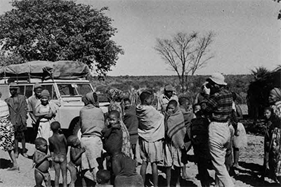 A field day for the author's wife-photographer. Note our well-laden LandRover in the left background. The bushy low vegetation that stretches all the way  to the horizon is typical in that part of the  Kalahari Desert. 