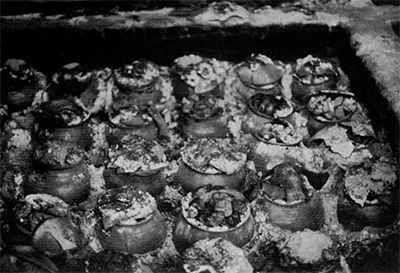 Heat treatment of agates before they are chipped. Nodules are placed in small pots along with sawdust which is then lit and allowed to burn slowly