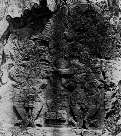 Maya monument, showing a carvng of two figures and some glyphs.