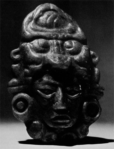 Jade pendant in the shape of a head and tall headdress.