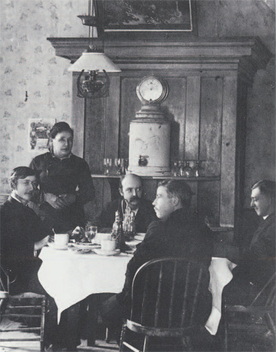 Interoir of the Cosmopolitan, 1880s. L to R: W.O. Carbis, son of the mine manager, Michael Carbis, whose murder in October 1880 led the only lynching in Silver REef's history; Mrs. Margaret Grambs, proprietor of the Cosmopolitan; Crockwell and Ottinger (seated), the photographers from Salt Lake City; Charels Case, owner of the drugstore opposite from the restaurant on the east side of Main street, excavated in 1985 (Courtesy of the Utah State Historical Society)