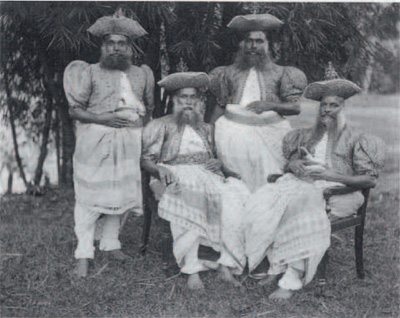 The ancient costume of the Kandyans, the inhabitants of Ceylon (Sri Lanka), replete with cummerbunds, finger rings, and daggers. Photo by C.T. Scowen, ca. 1898.