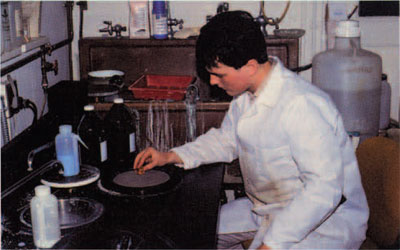 A student is polishing a mounted and ground sample on a polishing wheel.