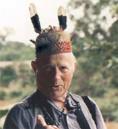 Robert L. Trescher dons a Dayak chief's hat in Kalimantan (Borneo) on the 1990 Women's Committee tour to Borneo and Indonesia. The tour was led by William Davenport.