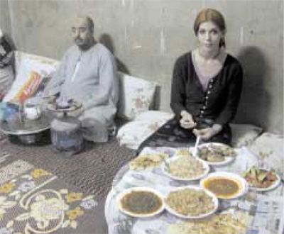 Linda Harris (visiting artist at the Giza Plateau) sits before an array of Middle Eastern dishes presented by the family of one of our workmen in a small village near Cairo.