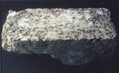 A brick with a colorful painting of gods, the brick has been worn away in parts.