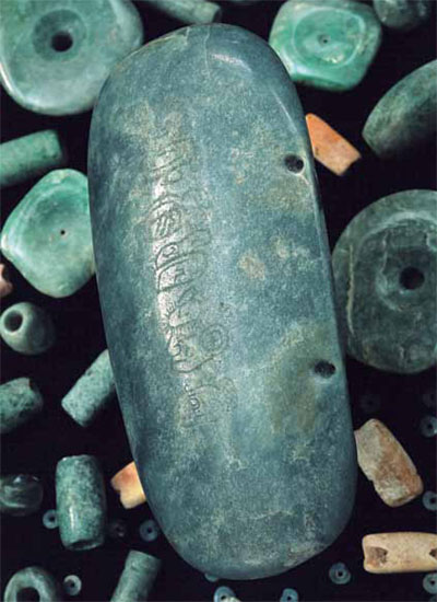 A stone with incised glyphs in a column down the center.