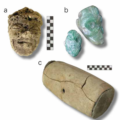 Three small artifacts in the shape of heads, and a oval container.