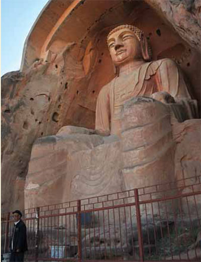 Colossal statue of Maitreya Buddha cut directly into a cliff face.