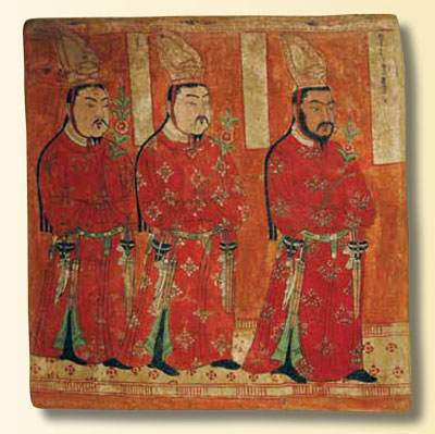 A mural depicting three Buddhists in red robes and tall headpieces.
