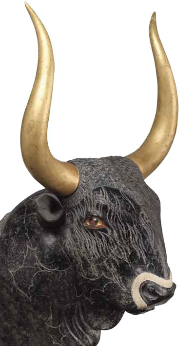 A black rhyton in the shape of a bull's head, with tall gold horns and white inlay to portray hair.