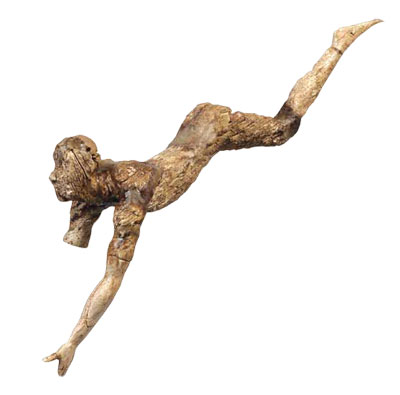 An ivory figurine of a person mid leap over a bull, arms and legs outstretched.
