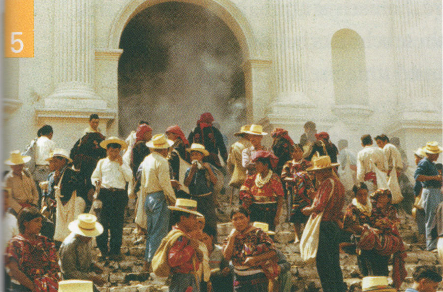 A group of people on the front steps of a building, burning resin.