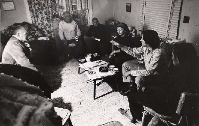A group of people seated on couches, having a conversation.