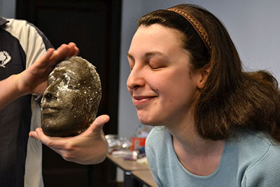 A graduate student and the mask made from a mold of her face.