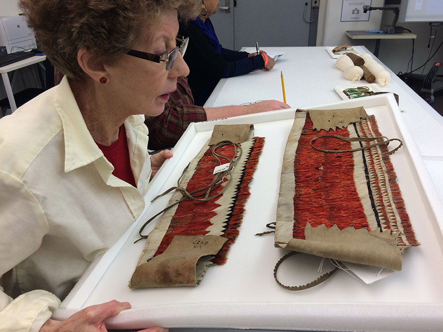 JoAnn Adams, a Special Education teacher from the School District of Philadelphia, gets a closer view of an intricate feather headdress from the Hupa Nation during the Teacher Institute.