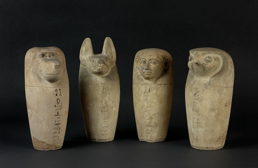 Four canopic jars with different animal head lids.