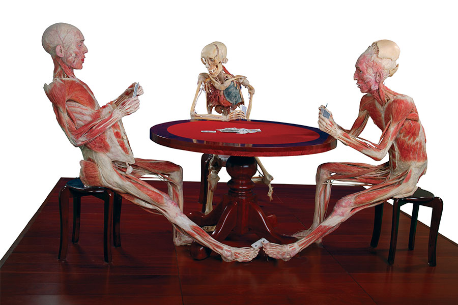 Three musculatures of people seated at a table playing poker.