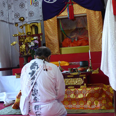 A pilgrim kneeling at an altar.