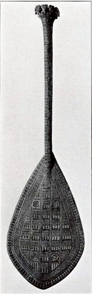 A paddle with detailed carvings covering its surface