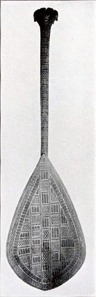 A paddle with detailed carvings covering its surface