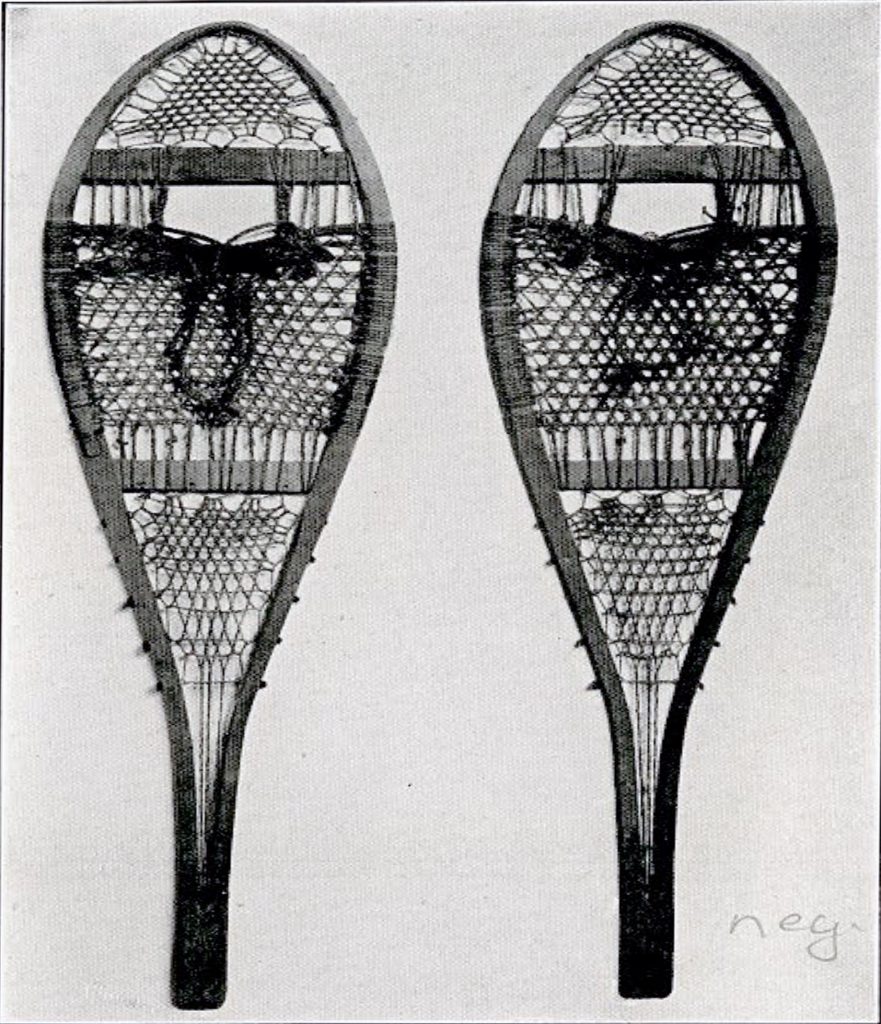 A pair of long snowshoes, round at the top and narrow at the back