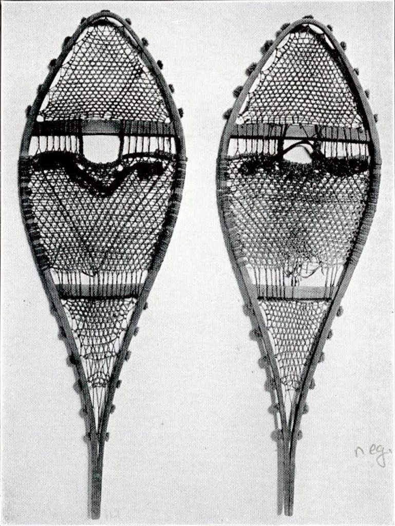 A pair of snowshoes with small tufts along the outside