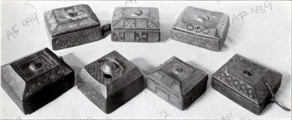 A set of seven square wooden boxes with various patterns carved into them