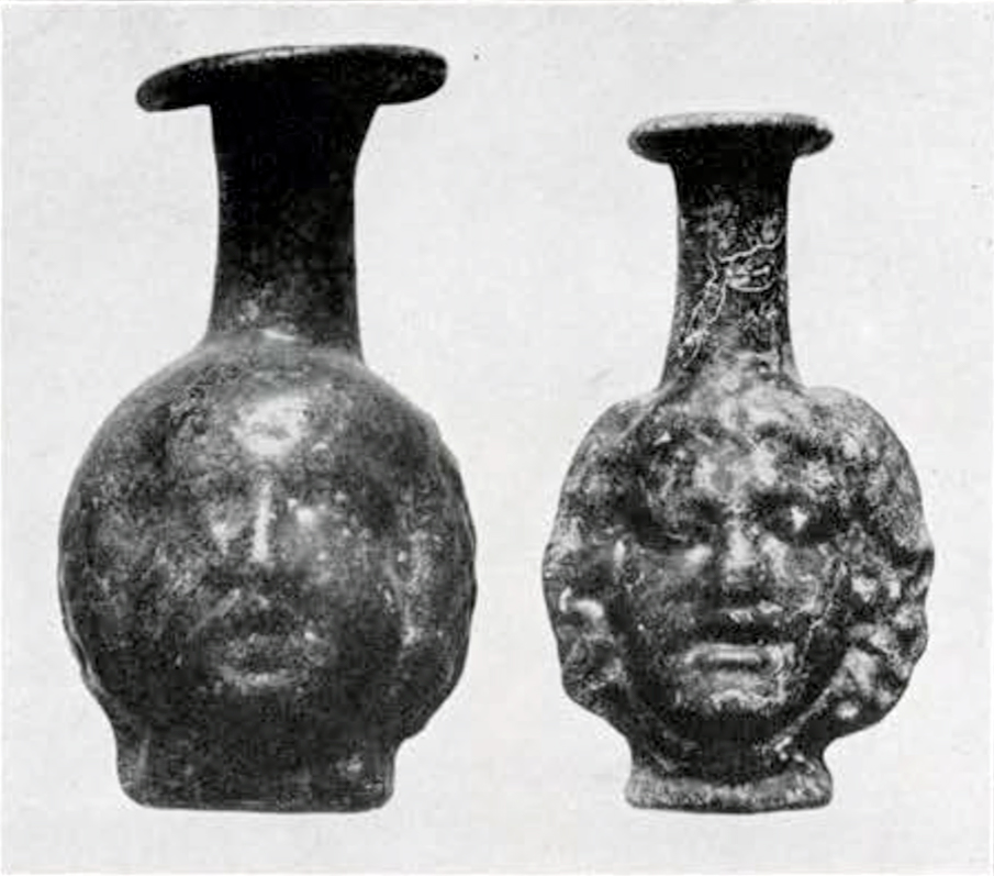 Two small vases or bottles with bodies molded to look like heads