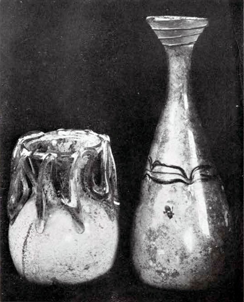 Two vases, left short with zigzag ornamenting from shoulder to lip, right tall vase with funnel mouth