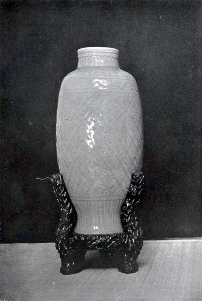 Oval celadon vase with a neck on an ornate tripod base
