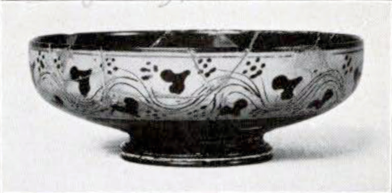 A shallow, flat bowl with a pattern of ivy garland on a wall