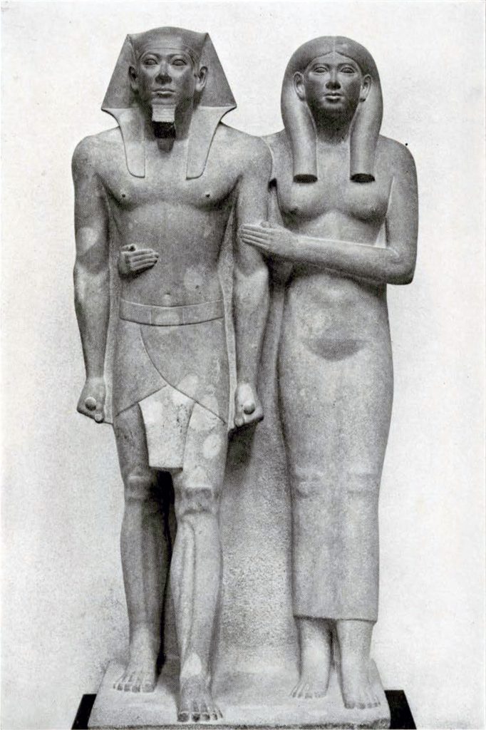 A statue of a king and his queen standing next to each other