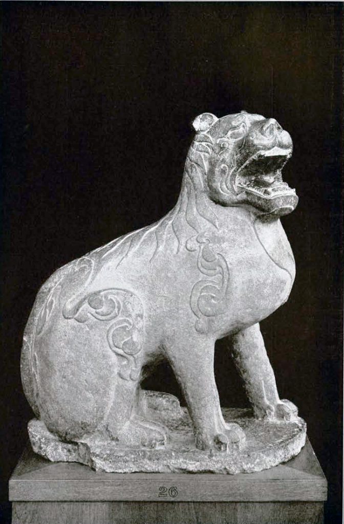Stone sculpture of a seated line withan open mouth and low relief fur details