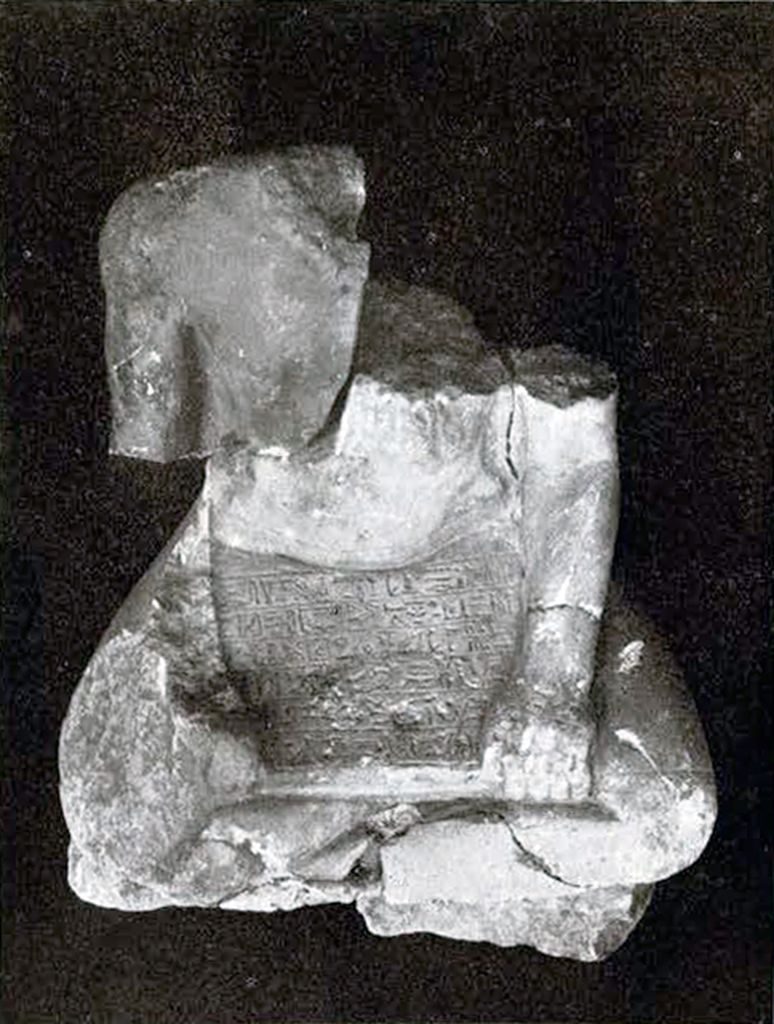 Piece of a statuette of a seated, cross-leegged high priest, head missing
