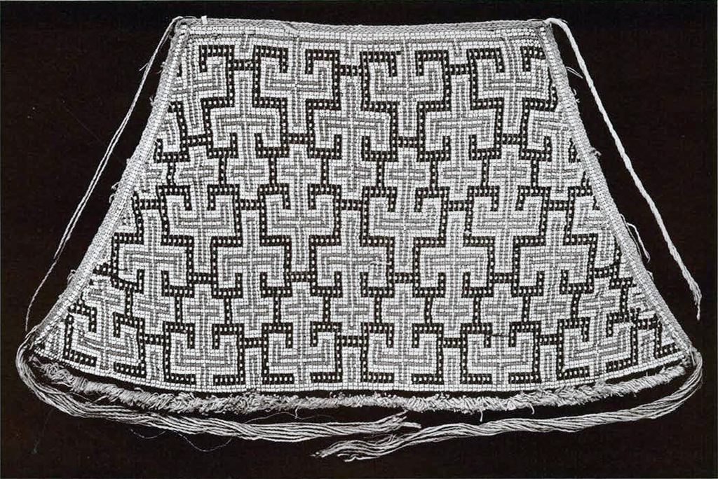 A beaded apron with an interlocking repeated pattern