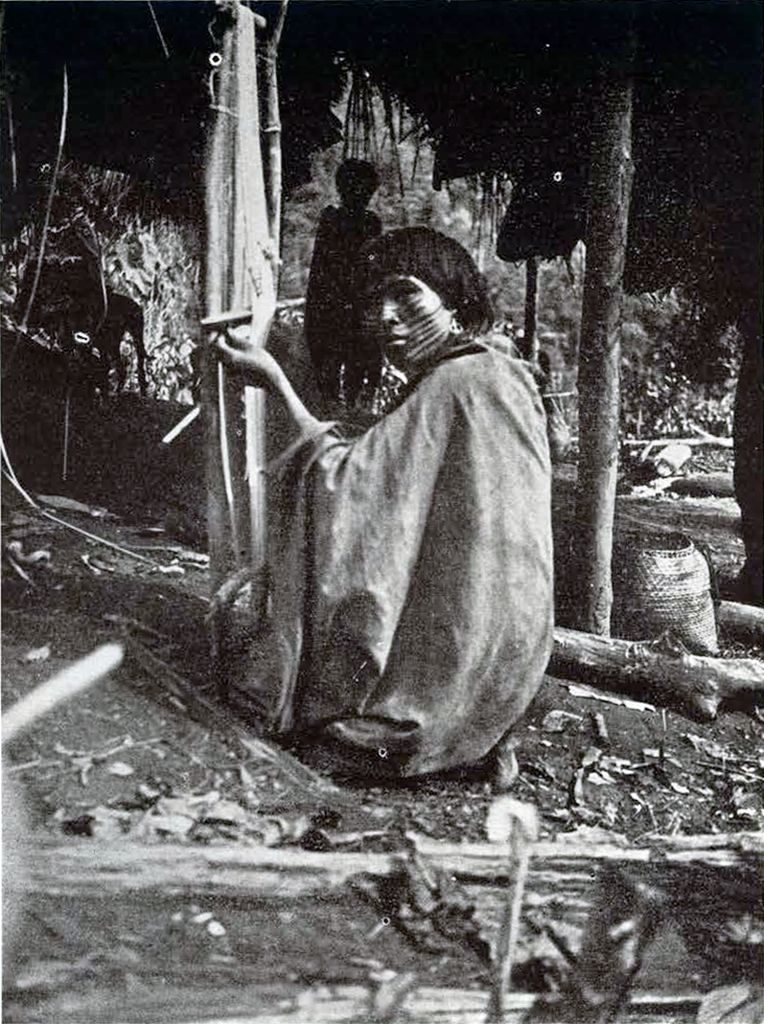 Macoa midway through weaving a headdress