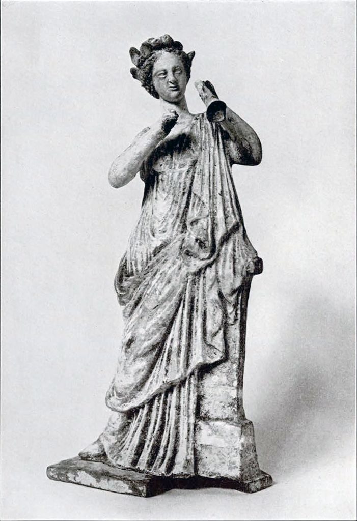 A terracotta figurine of a muse playing the double flute